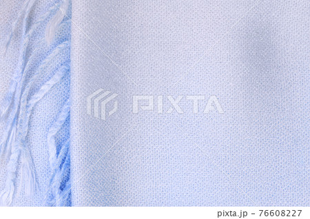 Background textile with a texture of a knitted scarf with a fringe, blue fabric with a color gradient in pastel shades, clothing and accessories Background textile with a texture of a knitted scarf with a fringe, blue fabric with a color gradient in pastel shades, clothing and accessories 76608227