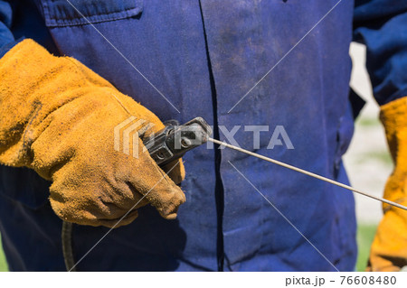 Profession welder, working specialty, equipment tool for welding metals electrode holder in the hands of a man at work, employment and labor Profession welder, working specialty, equipment tool for welding metals electrode holder in the hands of a man at work, employment and labor 76608480