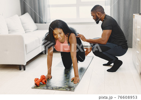 Handsome Afro American couple working out at home Handsome Afro American couple working out at home 76608953