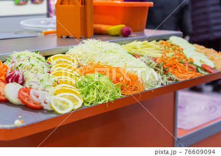 Fresh raw chopped chopped grated vegetables and fruits tomato radish onion cabbage cucumber carrots potatoes lemon orange on the table, the concept of proper healthy nutrition and vegetarianism 76609094