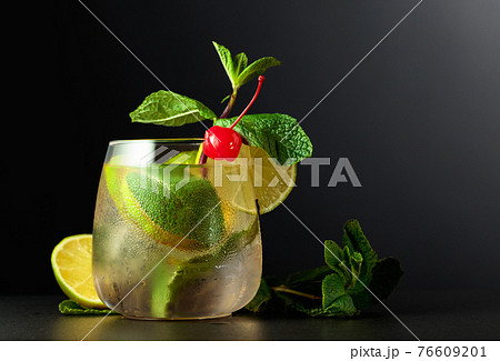Frozen glass with a Mojito garnished with a preserved cherry. Frozen glass with a Mojito garnished with a preserved cherry. 76609201