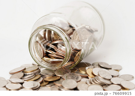 Coins in glass bottle on white background 76609915