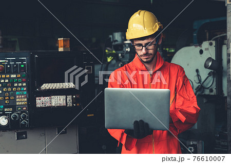 Skillful factory worker working with laptop computer to do procedure checklist . 76610007