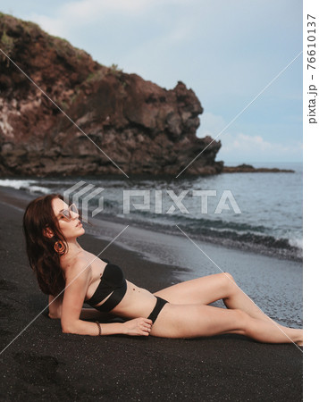Girl in a stylish swimsuit have a rest n a beach 76610137