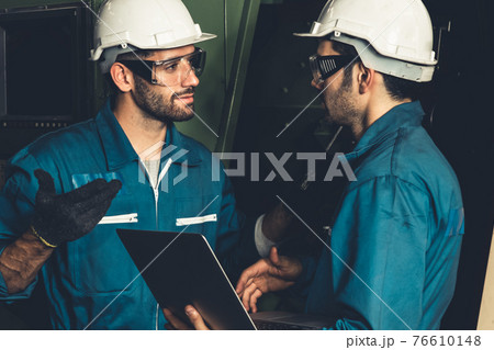 Group of skillful factory workers using machine equipment in workshop 76610148