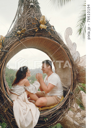 Couple sitting in a large nest on a Bali 76610194