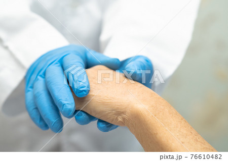 Doctor holding touching hands Asian senior or elderly old lady woman patient with love, care, helping, encourage and empathy at nursing hospital ward 76610482