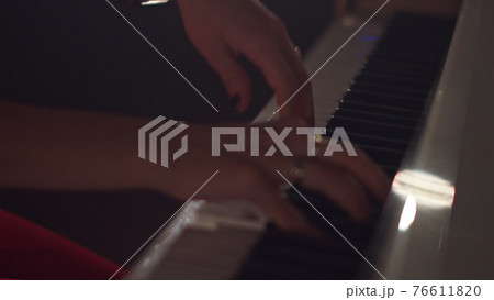 A female young hands playing piano in black manicure and accessories. Classical music pattern. Girl playing piano keywords A female young hands playing piano in black manicure and accessories. Classical music pattern. Girl playing piano keywords 76611820