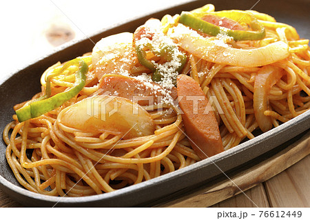 鉄板に盛り付けられているタマネギ、ピーマン、ウィンナーが入ったナポリタン 76612449