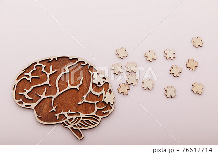Alzheimer's disease and mental health concept. Brain and wooden puzzle on a pink background 76612714