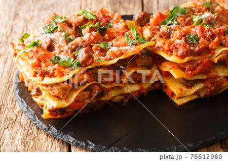 Lasagna Vincisgrassi Recipe with chicken giblets, beef, pork and vegetables close-up on a slate board. horizontal 76612980