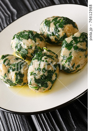 Strangolapreti in Trentino Italian bread and spinach dumplings close-up in a plate. Vertical 76612988