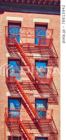 Old residential building with red fire escapes, New York City, USA. Old residential building with red fire escapes, New York City, USA. 76613942