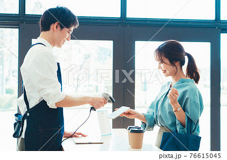 スマホ決済をする若い女性 スマホ決済をする若い女性 76615045