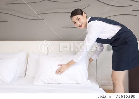 High angle view of a waitress making the bed, Housekeeper cleaning a hotel room High angle view of a waitress making the bed, Housekeeper cleaning a hotel room 76615399
