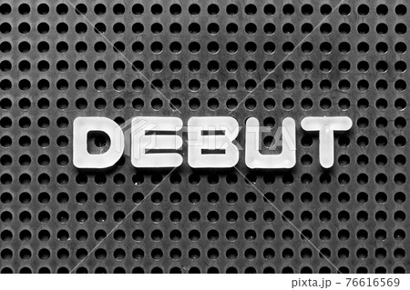 White alphabet letter in word debut on black pegboard background 76616569