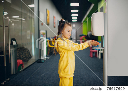 Child girl using automatic alcohol gel dispenser spraying on hands sanitizer machine antiseptic disinfectant, new normal life after Coronavirus COVID-19 pandemia Child girl using automatic alcohol gel dispenser spraying on hands sanitizer machine antiseptic disinfectant, new normal life after Coronavirus COVID-19 pandemia 76617609