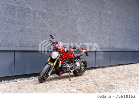 Sporty racing powerful stylish modern red motorcycle stands parked on the road Sporty racing powerful stylish modern red motorcycle stands parked on the road 76618162