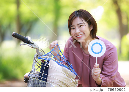 自転車用ネットを着け〇札を持つ女性 76620002