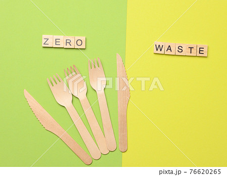 disposable wooden forks and knife for fast food and picnic on a green background disposable wooden forks and knife for fast food and picnic on a green background 76620265