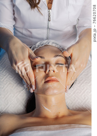 Professional beautician woman massaging face to Professional beautician woman massaging face to 76620708