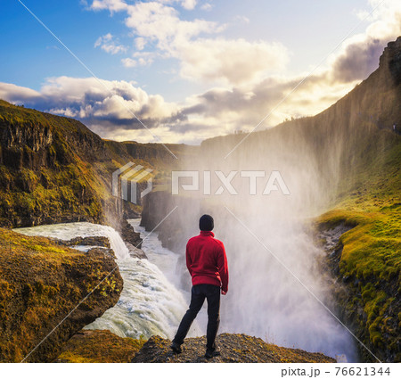 Young hiker standing at the edge of the Gullfoss waterfall in Iceland Young hiker standing at the edge of the Gullfoss waterfall in Iceland 76621344