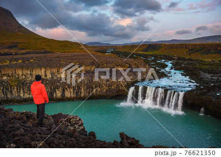 Hiker standing at the edge of the Thjofafoss waterfall in Iceland 76621350