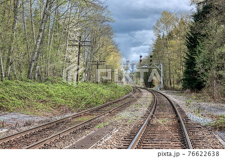 Curve of rail road pathways leading to a city 76622638