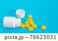 Yellow pills and plastic white bottle 76623031