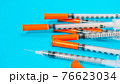 Insulin vial and syringe on blue background 76623034