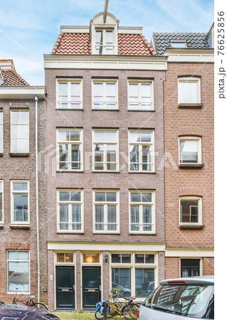 Facade of classic brick residential building in city 76625856