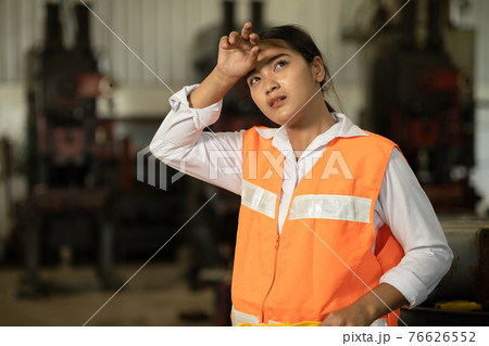 Tired woman worker Asian labor hard work in hot factory wiping away sweat 76626552