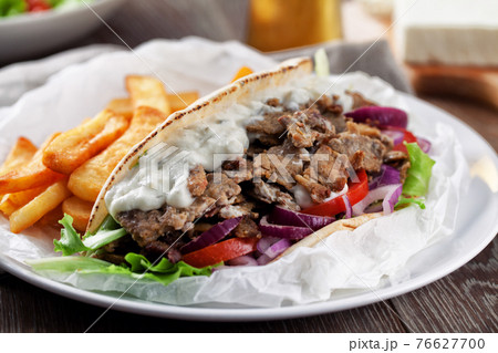 Greek Gyros with Fries and Salad on a Plate. Greek Gyros with Fries and Salad on a Plate. 76627700