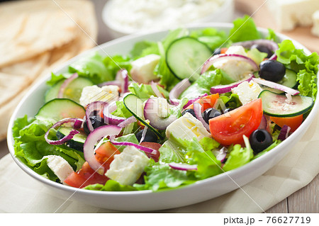 Greek salad with tomatoes, feta, olives and cucumbers. Greek salad with tomatoes, feta, olives and cucumbers. 76627719
