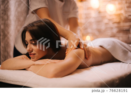 Masseuse does back massage to young woman in spa centre, close-up. Masseuse does back massage to young woman in spa centre, close-up. 76628191