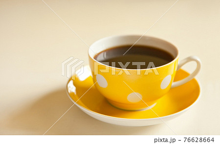 cup of black tea on yellow plate. yellow cup with dots. retro style. vintage mug 76628664