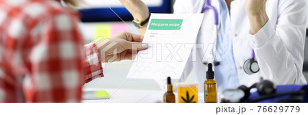 Doctor giving patient prescription for drug in clinic 76629779