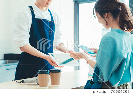レジでの会計でスマホ決済の準備をする女性 76634202