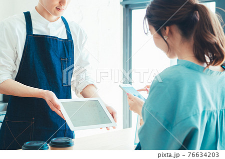 レジでの会計でスマホ決済の準備をする女性 76634203
