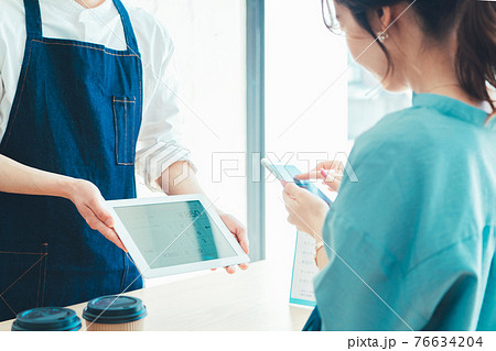 レジでの会計でスマホ決済の準備をする女性 76634204
