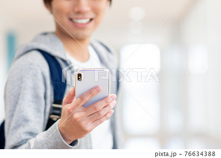 スマホを見る大学生の男性 撮影協力:中央工学校附属日本語学校 スマホを見る大学生の男性 撮影協力:中央工学校附属日本語学校 76634388