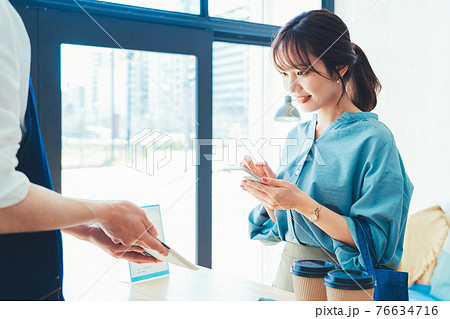 レジでの会計でスマホ決済の準備をする女性 76634716