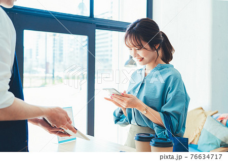 レジでの会計でスマホ決済の準備をする女性 76634717