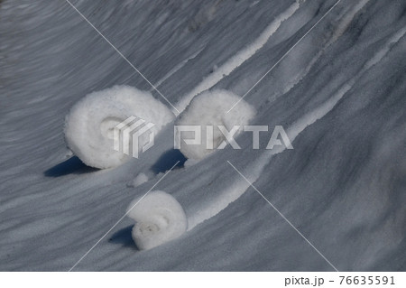 雪の斜面を3つの雪玉が転がる 76635591