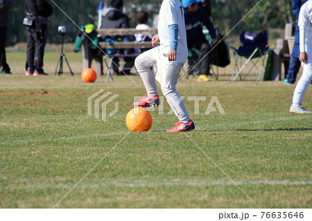 サッカーの試合でサッカーボールを蹴る少年 76635646