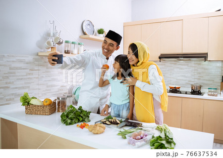 muslim asian family take selfie during iftar dinner preparation 76637534