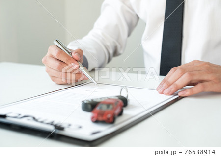Car dealer businessman signing car insurance document or lease paper. Car loan and insurance concept 76638914