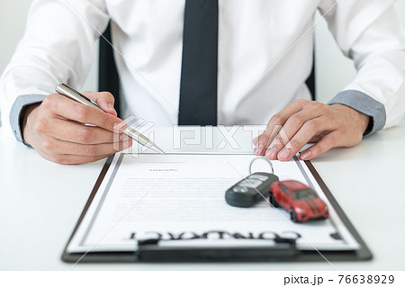 Car dealer businessman signing car insurance document or lease paper. Car loan and insurance concept Car dealer businessman signing car insurance document or lease paper. Car loan and insurance concept 76638929
