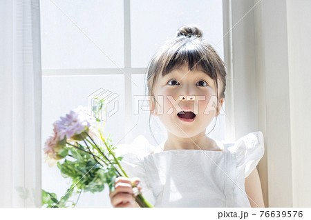 窓辺で花を持つ女の子 76639576