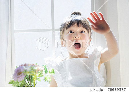 窓辺で花を持つ女の子 76639577